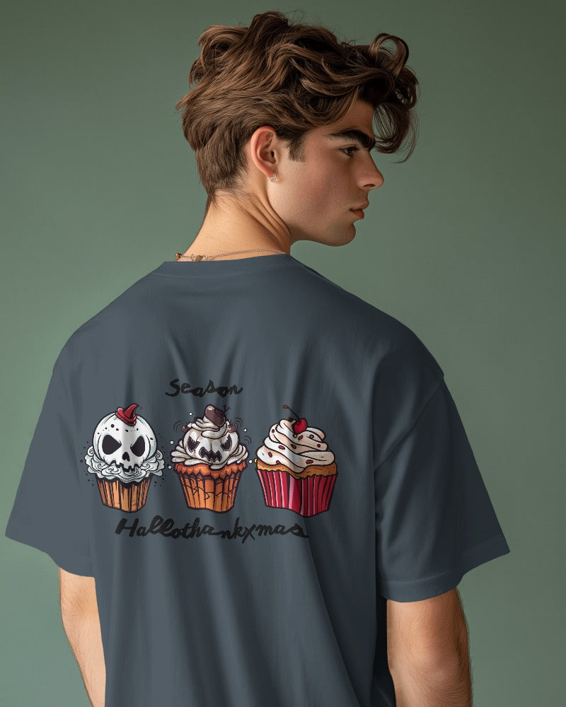 Männliches Modell trägt ein indigoblaues Unisex Oversize T-Shirt mit „ThanksXmas“-Aufdruck auf der Rückseite. Kombination aus Halloween- und Weihnachtsmotiven.